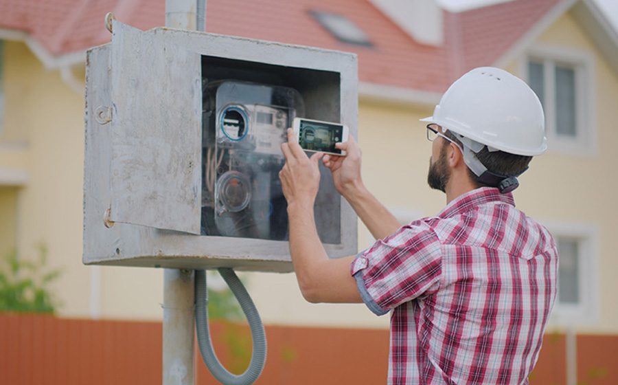 field worker using mobile phone to inspect gas meter