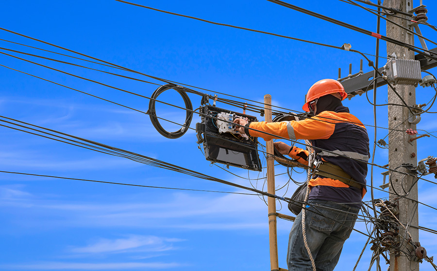 telecom field worker installing fiber optic cables on pole with digital work instructions
